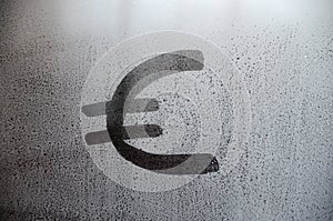 The euro currency symbol on the misted sweaty glass. Abstract background image. Euro currency concept