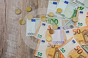 Euro, dollars, cents spread out on a wooden background
