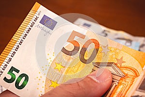 Euro, European Union Currency. A man holding a fifty Euros banknote.