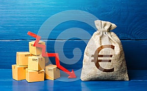 Euro money bag with boxes and down arrow. Income decrease, slowdown and decline of economy. Low sales. Production decline. Reduced photo