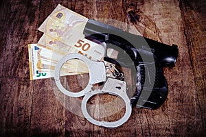 Euro Money banknotes and handcuffs on wooden background. Dark image for corruption, fraud, money laundry concept