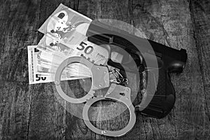 Euro Money banknotes and handcuffs on wooden background. Dark image for corruption, fraud, money laundry concept