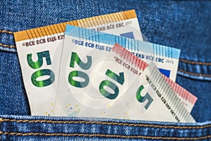 Euro money banknotes in a pocket of blue jeans close up