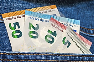 Euro money banknotes in a pocket of blue jeans close up