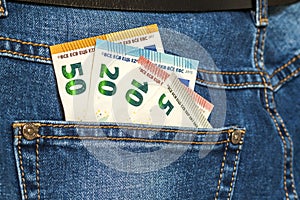 Euro money banknotes in a pocket of blue jeans close up