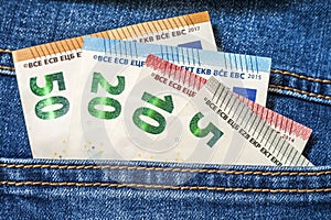 Euro money banknotes in a pocket of blue jeans close up