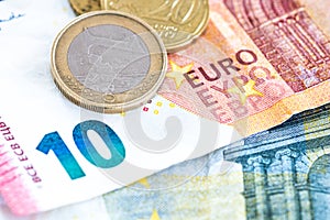 Euro money cash, 10 and 5 euro banknotes with 1 euro coin in main subject as a backdrop for topics such as economics, finance,