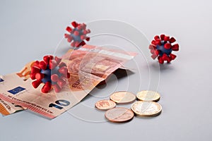 Euro money, coins and models of covid-19 virus on blue background.Contaminated infected cash money. Economy crisis