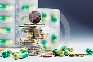 Euro money and medicaments. Euro coins and pills. Coins stacked on each other in different positions and freely pills around photo