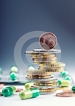 Euro money and medicaments. Euro coins and pills. Coins stacked on each other in different positions and freely pills around