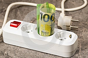 Euro money paper banknote inserted into an extension socket