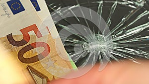 Euro money, Weakening of European currency, business concept, Euro zone currency thrown on cracked glass, dark background.