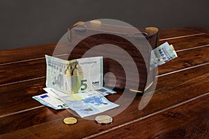 Euro money and wooden piggy bank on the table