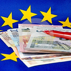 Euro notes and red pencil, EU flag