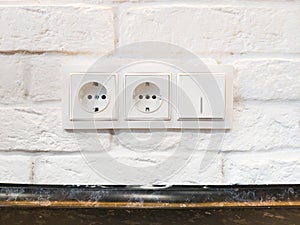 Euro plug socket on white brick wall