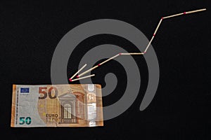 Euro rise and fall graph, banknote on black background