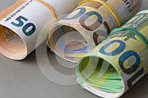 Euro in rolls background. Fifty, one hundred and two hundred euro bills are rolled up.