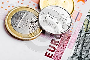 Euro and ruble coins on euro banknotes