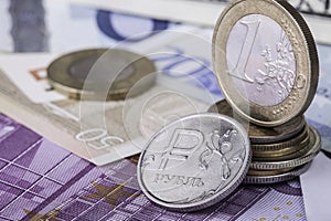 Euro and ruble coins on european banknotes