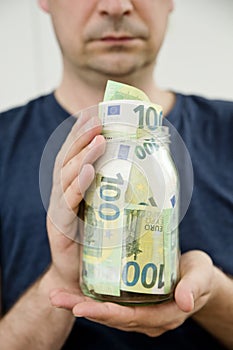 Euro`s in a jar, some banknotes out from it.