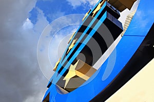 Euro sign at European Central Bank headquarters in Frankfurt, Germany with dark dramatic clouds symbolizing a financial crisis.