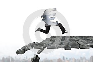 Euro symbol with human legs running on breaking puzzle ground