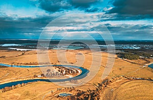 Europe. Aerial View Of Dry Grass And Partly Frozen Curved River Landscape In Autumn Day. High Attitude View. Marsh Bog