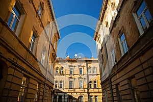 Europe old city street narrow path way between medieval buildings exterior facades symmetry urban landmark square shape view from