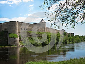 Europe. The photo of old fortress on the background and blossom apple tree and river are on the foreground. The blue sky with clou