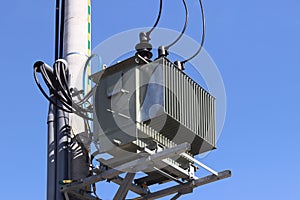 Europe. Poland country. Electrical technology. Tranformer of pawer in sunlight on a blue sky background. Electrical equipment of n