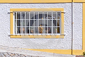 Barred window on a white stucco building photo