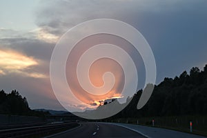 Europe, Slovenia rural road with clouds and sun rays over the sky