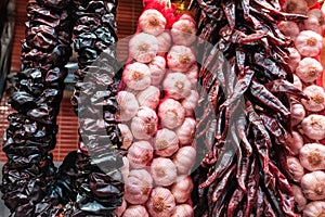 Europe, Spain. Bundles of dry garlic and hot peppers in the market of Barcelona