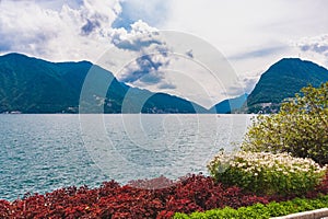 Europe. Switzerland.Park in Lugano, lake, mountains. Blue sky with clouds.