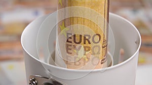 European banknote is inserted into an electric lamp holder.