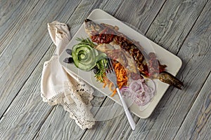 The european bass Dicentrarchus labrax with vegetables on a plate close-up