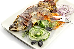 The european bass Dicentrarchus labrax with vegetables on a plate close-up