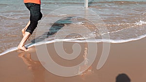 European bearded man running on sea beach. Freedom concept. Male tourist runs barefoot on amazing summer seashore. 4K.