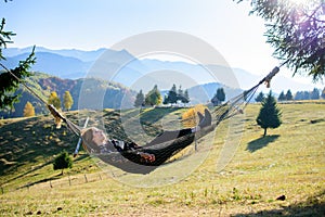 Relaxation. Women in hammock in autumn. mountain view photo