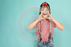 European boy in a red T-shirt with buckles on a light blue background.