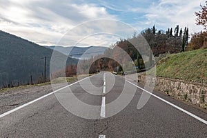 European country road. Turn right, road sign, trees and bright blue sky. Asphalt and dry grass.