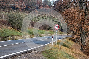 European country road. Turn right, road sign, trees and bright blue sky. Asphalt and dry grass.