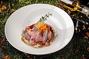 European cuisine. Marinated veal with roast Medium rare. Degree of roasting. Chef pours beef olive oil. Serving dishes