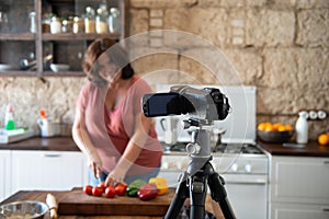 European curvy woman in her home kitchen making content for his influencer channel