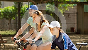 European family riding bicycles in park