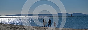 A European family walks along a sandy beach