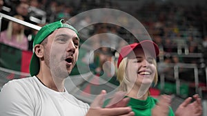 European fans shout at soccer stadium. Happy couple cheering clap football arena