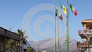 European flags on flagpoles fluttered in the wind. Ukrainian and Italian flags.