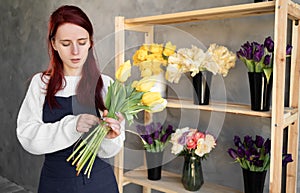 European flower shop concept. A female florist creates a beautiful bouquet of spring tulip flowers. Beautiful fresh