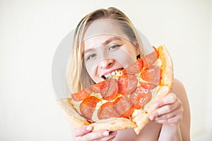 European girl with short hair posing with pieces of delicious pizza.